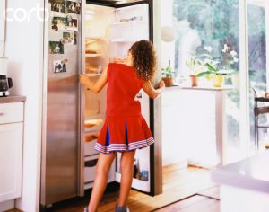 Girl in Cheerleader Uniform Looking Through Refrigerator